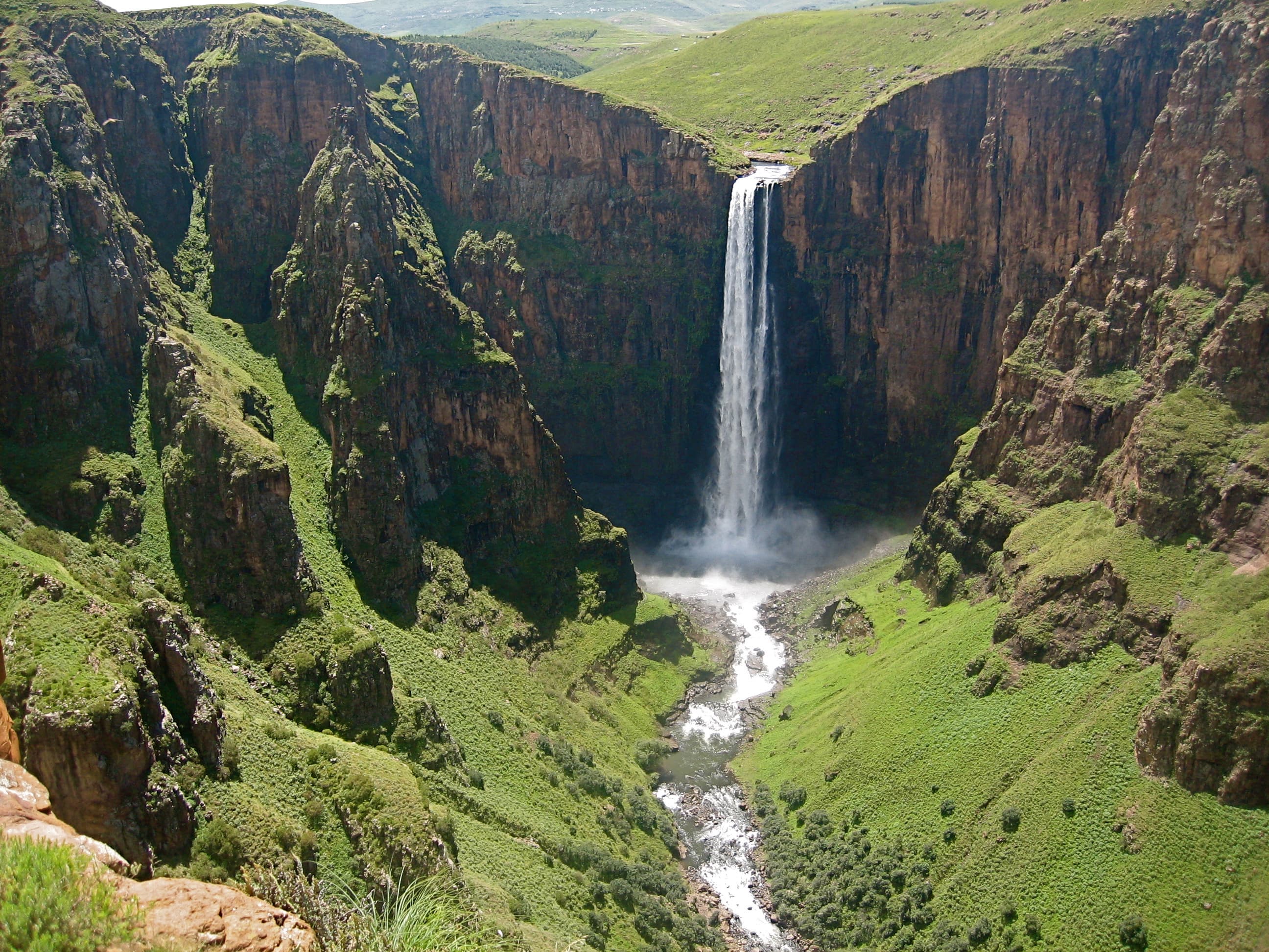 Maletsunyane Falls plunging into a deep gorge surrounded by green highland hills