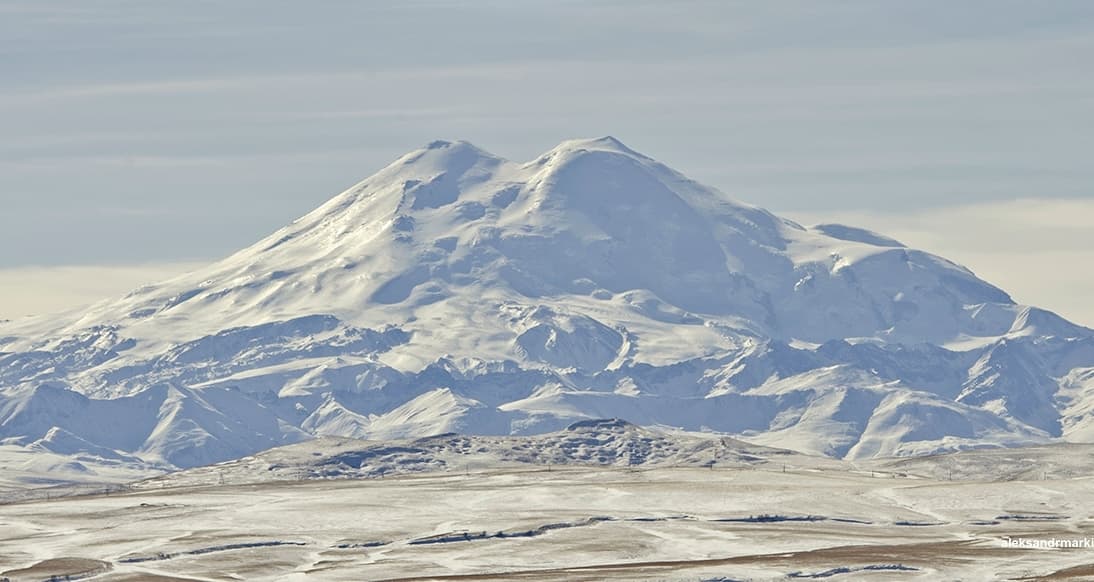 The snow-capped twin peaks of Mount Elbrus rising above the Caucasus Mountains