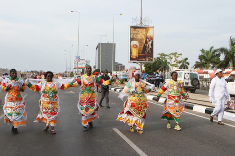Parade of dancers in brilliant feathered costumes at Carnival de Luanda