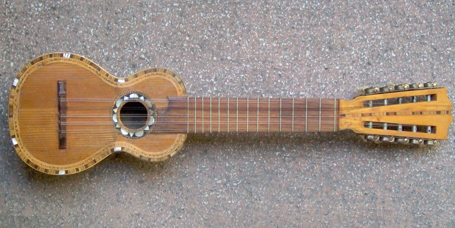 A charango with its small rounded body and ten strings being played by a musician