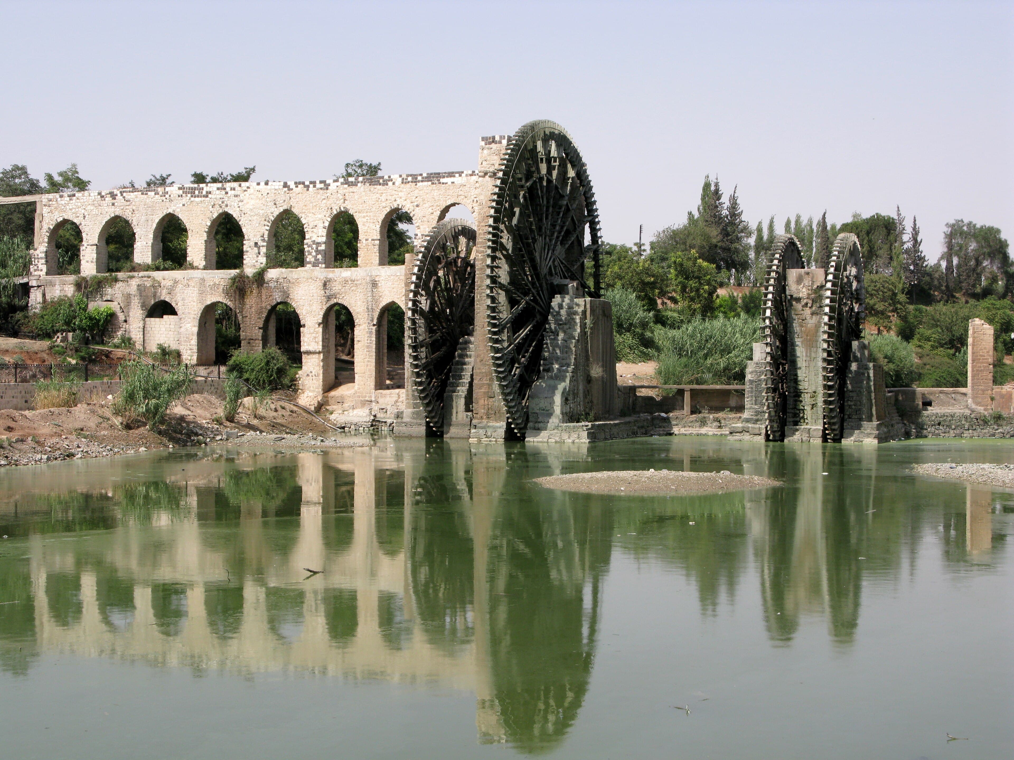 Large ancient wooden waterwheels turning in the Orontes River at Hama