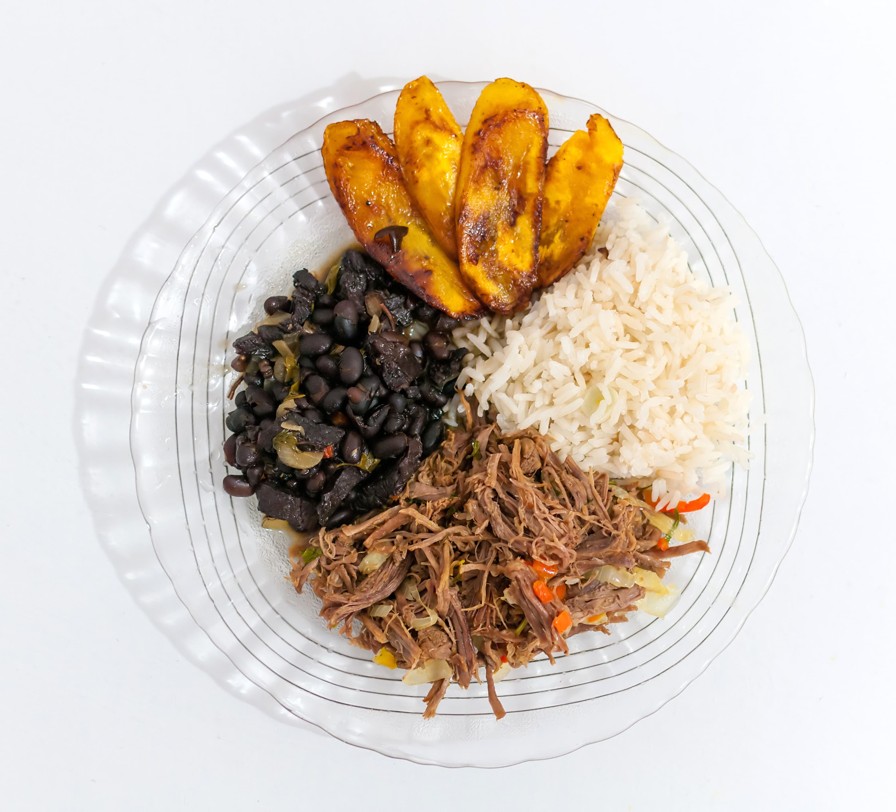 A plate of Venezuelan pabell贸n criollo with rice, black beans, shredded beef and plantain